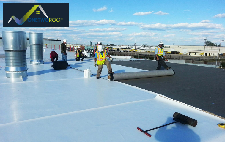 Workers installing TPO roofing on a commercial building.